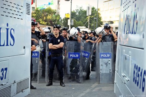Police officers stand behind two water cannon trucks in Taksim Square.