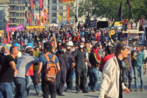 Protestors stand on the edge of Gezi Park, watching as hundreds of police officers entered Taksim Square with multiple water cannon trucks and other armored vehicles.