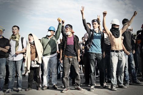 Protestors stand in front of a water cannon truck before cops began attacking protestors with tear gas, water cannons, and plastic bullets.
