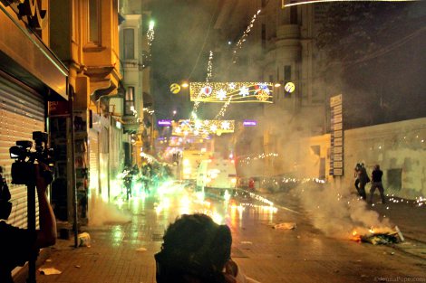 Protestors shooting fireworks at the police as the police shoot tear gas and water cannons at protestors.